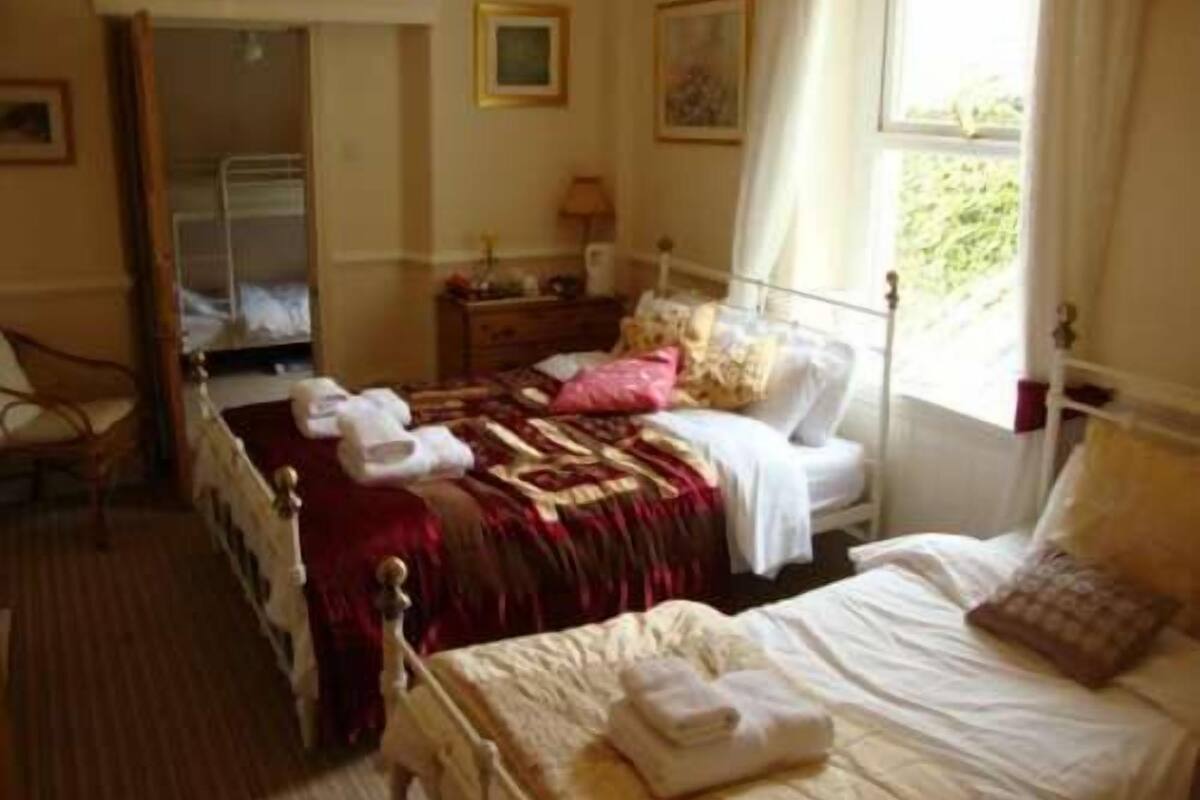 Ein Schlafzimmer mit Bett, Stuhl, Kommode und Fenster.