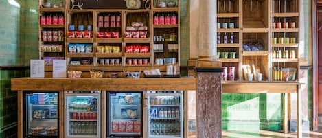 A market street with shelves stocked with canned goods, a chalkboard sign, and refrigerated display cases.