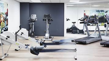 A gym with various exercise equipment including treadmills, a rowing machine, and a stationary bike.