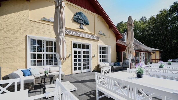 Un espace extérieur aménagé avec des meubles blancs et une terrasse en bois.