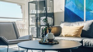 A modern living room with a round coffee table, a sofa, and a bookshelf. - Stoeberiet (Svendborg)