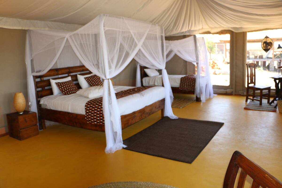 Une chambre avec un grand lit, une table de chevet et une chaise.