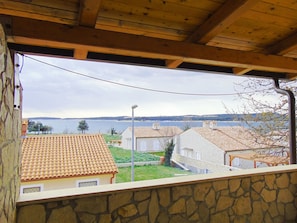 A view from a balcony overlooking a coastal area with terracotta-roofed houses, a clear sky, and a body of water in the distance. - Segundo al Mar Apartments (Medulin)