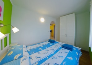 A bedroom with a bed, a wardrobe, a desk, and a lamp. - Pula Comfort Apartments (Pula)