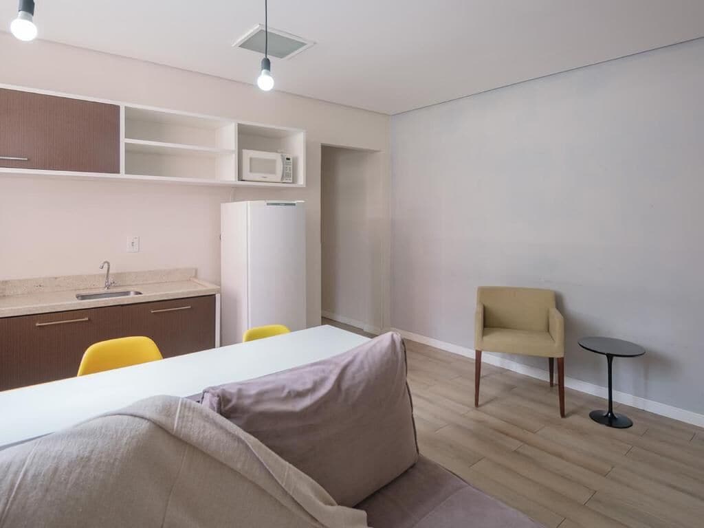 A modern, compact living space with a kitchenette, a dining area, and a seating area.