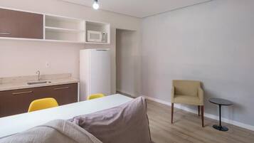 A modern, compact living space with a kitchenette, a dining area, and a seating area.
