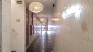 A corridor with a sign reading "SAÍDA" (exit), a staircase, and a wall with a neon light. - Açores Flat Design (Porto Alegre)