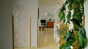 A room with a tiled floor, a white door, a wooden cabinet, and a plant. - Sol Jardin Apartments (Medulin)