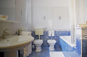 A bathroom with a sink, two toilets, a bidet, and a bathtub. - Sol Jardin Apartments (Medulin)