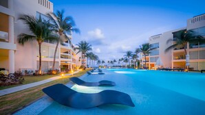 A swimming pool with modern architecture, palm trees, and a clear sky. - Elements GH8 by NAS (Playa del Carmen)