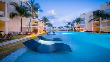 Alberca al aire libre, sombrillas en la alberca y camastros