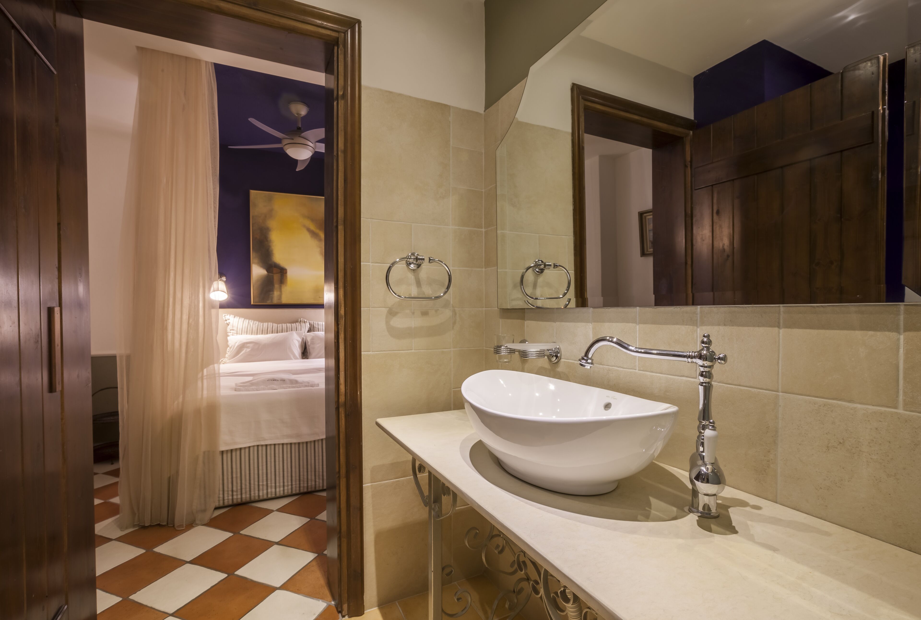 A bathroom with a white sink, a mirror, and a ceiling fan.