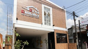 Un edificio de dos pisos con un letrero que dice 'Rin'taka MOTEL & PROJECT HOUSE'.