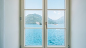 A window with a view of a lake and mountains. - Heritage Grand Perast (Perast)