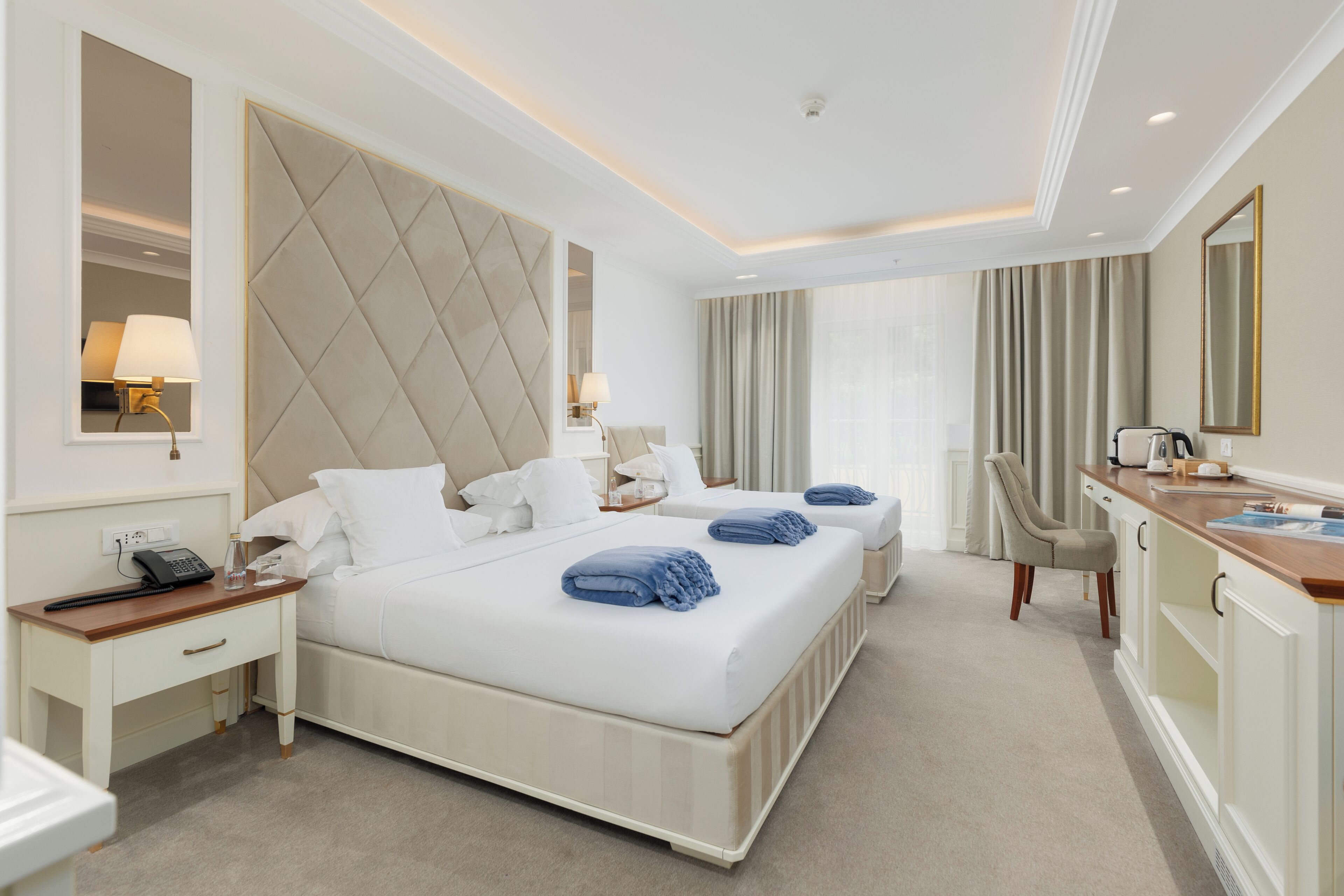 Une chambre d’hôtel avec un grand lit, des tables de chevet, un bureau et une chaise.
