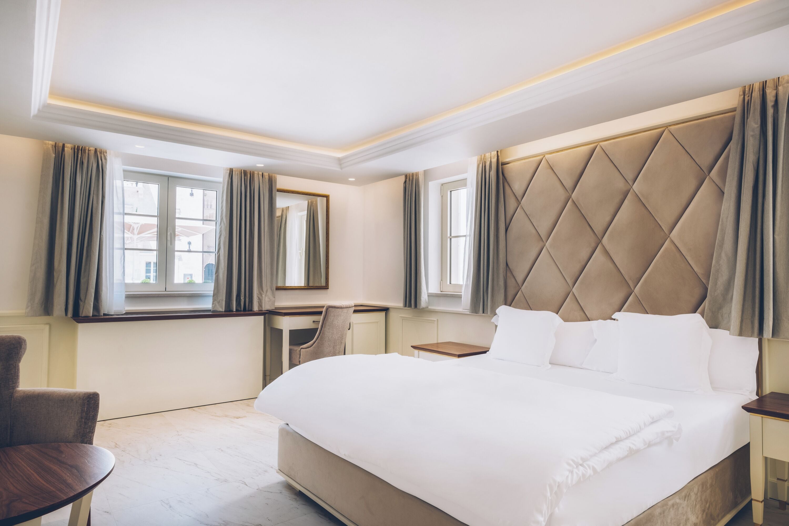 Una habitación de hotel con una cama grande, un escritorio y una silla.