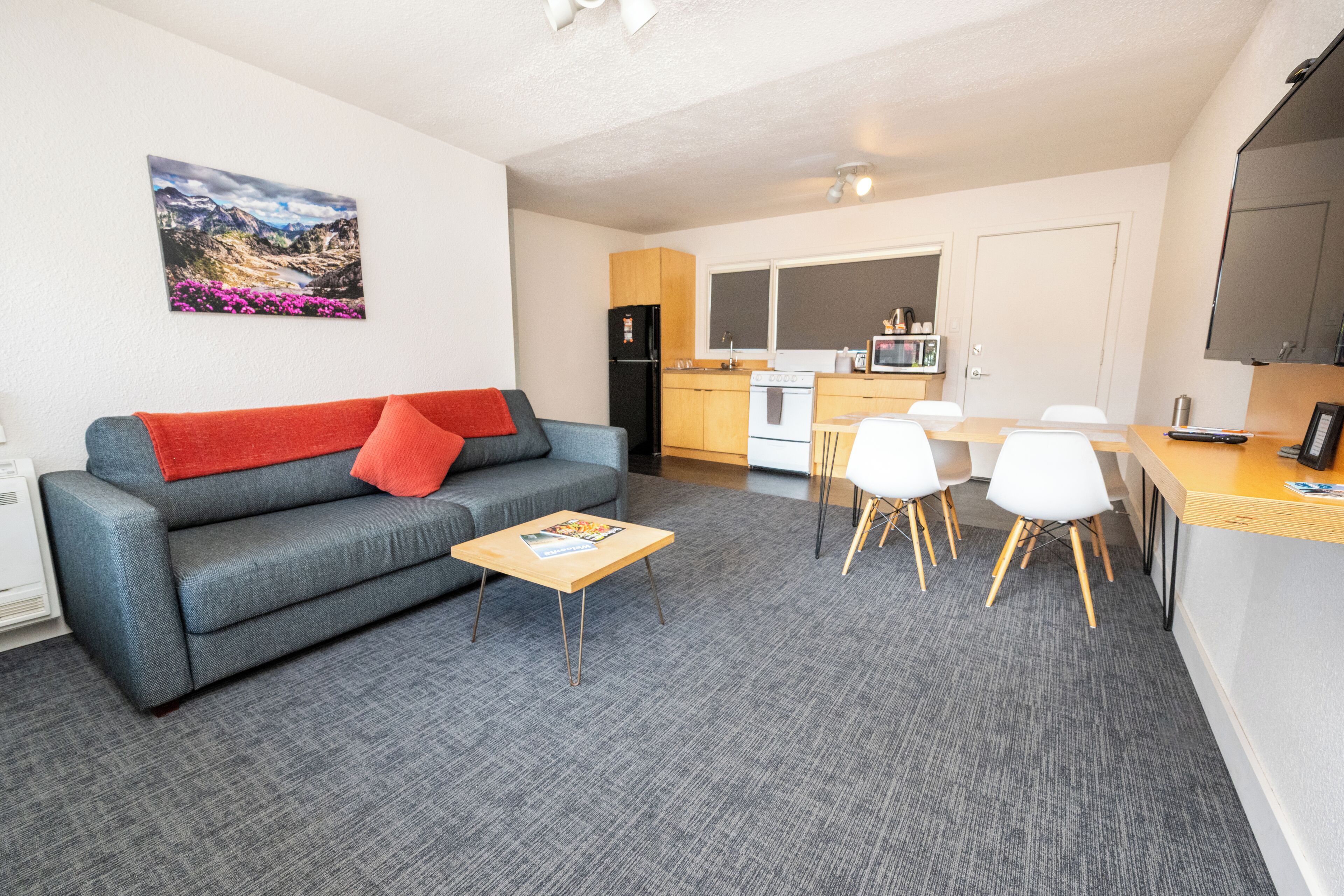 Un espacio habitable pequeño con sofá, una mesita de centro y un comedor con sillas y mesa.