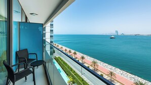 A balcony with a view of the sea, a chair, and a table. - Aloft by Marriott Palm Jumeirah (Dubai)
