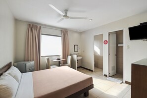 A hotel room with a bed, a desk, a chair, a television, and a bathroom visible through an open door. - Governor Forbes Inn - Manila City Center (Manila)