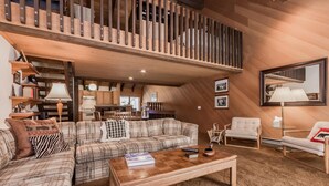 A spacious living area with a wooden staircase, a sofa set, a coffee table, and a dining area in the background. - Snowcreek 97 - Phase I (Mammoth Lakes)