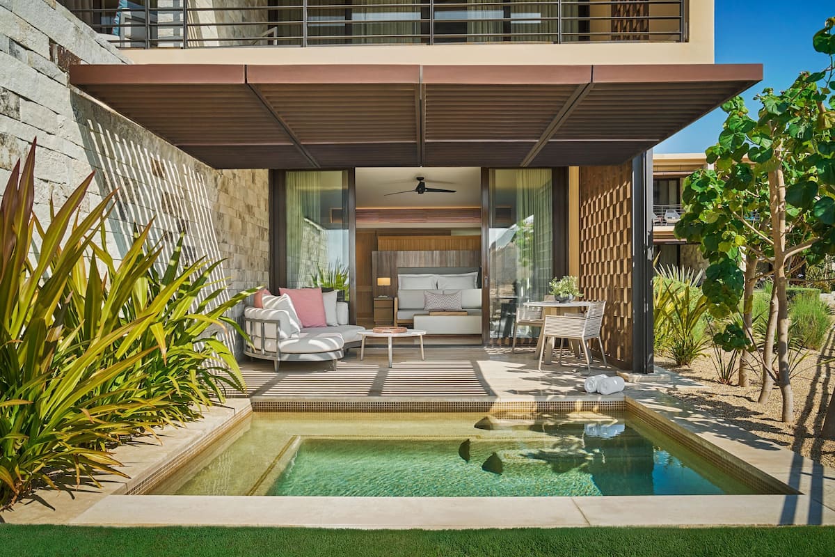 A modern house with a pool, outdoor seating, and a balcony.