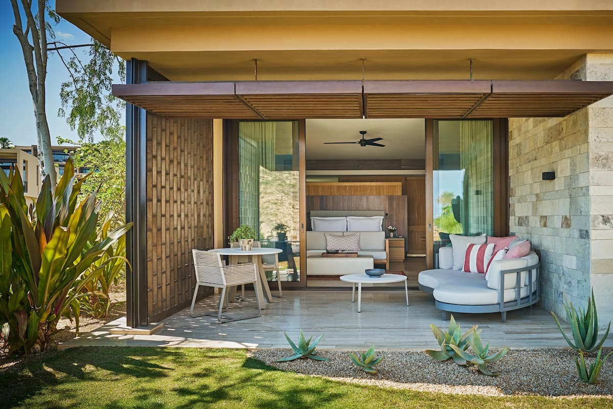 A modern outdoor living area with a sofa, chairs, and a table.