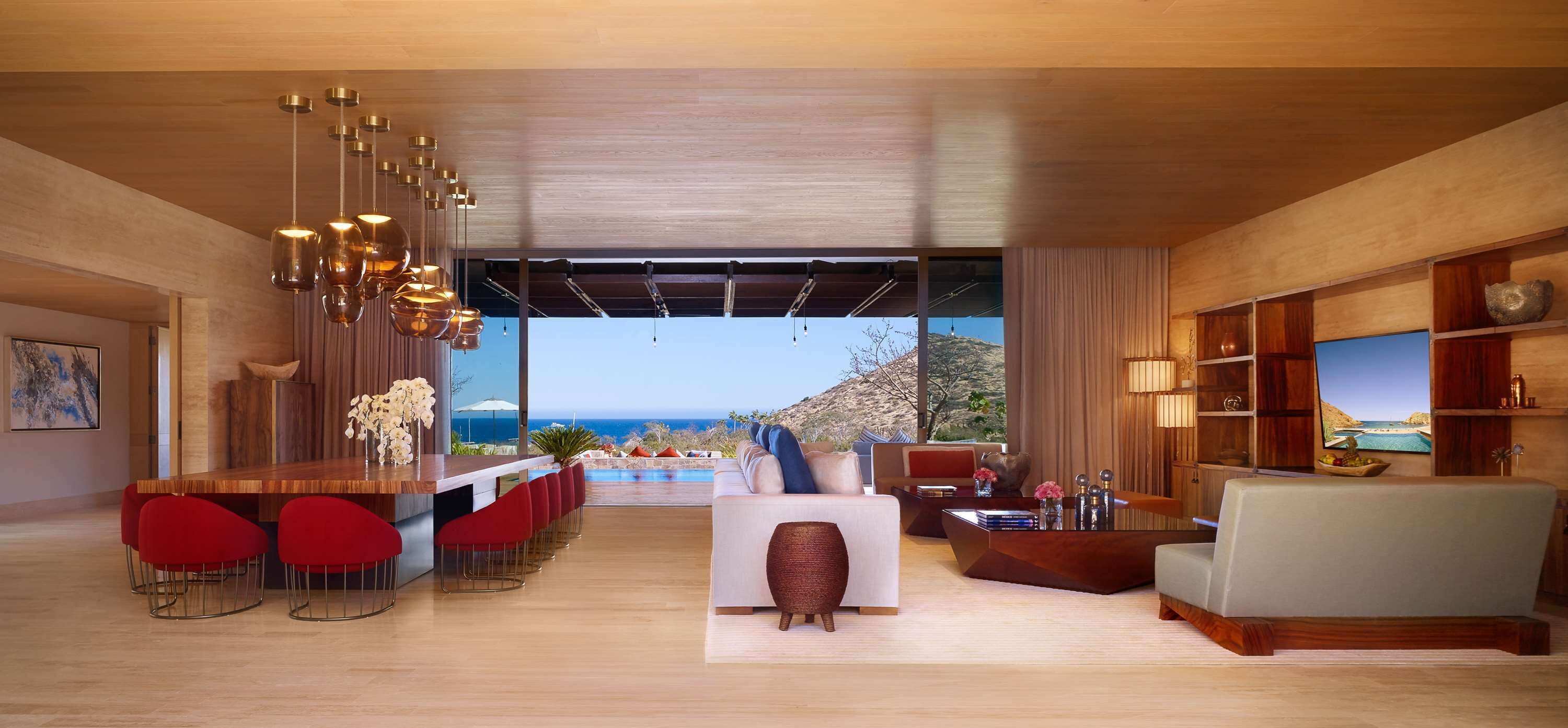 A modern living room with a bar area, a sofa, and a view of the ocean.