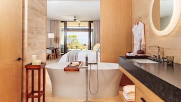 A modern bathroom with a bathtub, a vanity with a mirror, and a view of the outdoors.
