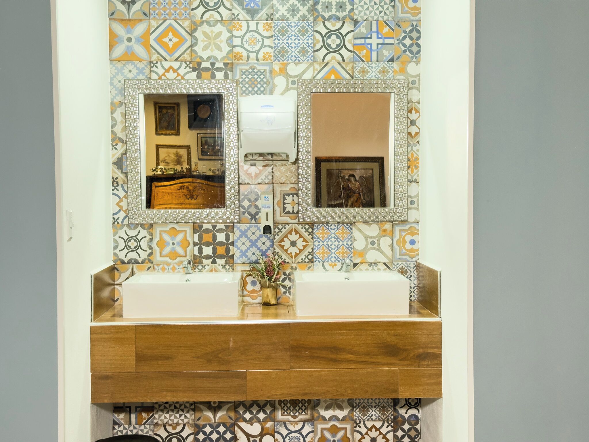 A bathroom with two sinks, a mirror, and a decorative tile backsplash.
