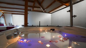 A spa room with a hot tub, candles, and a wooden ceiling. - Rose Petal (Srinagar)