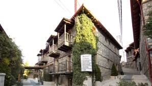Un edificio de piedra con un cartel que indica hotel, recepción, restaurante, piscina de spa y cafetería.