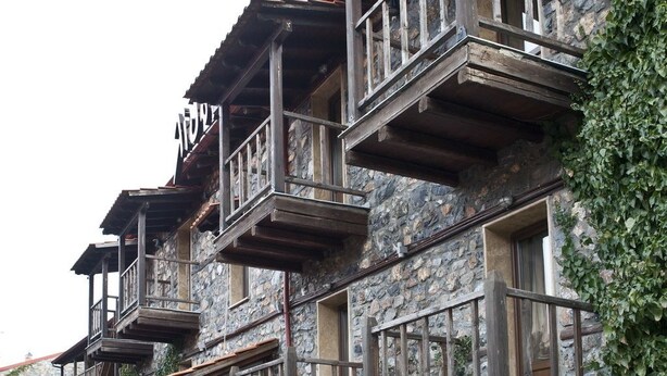 Un edificio de piedra con balcones de madera y un cartel que dice 'Hotel'.
