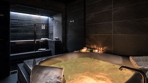 A hot tub in a dark room with tiled walls and a bench. - Villa Liberty - Lake Como Rooms & SPA (Como)