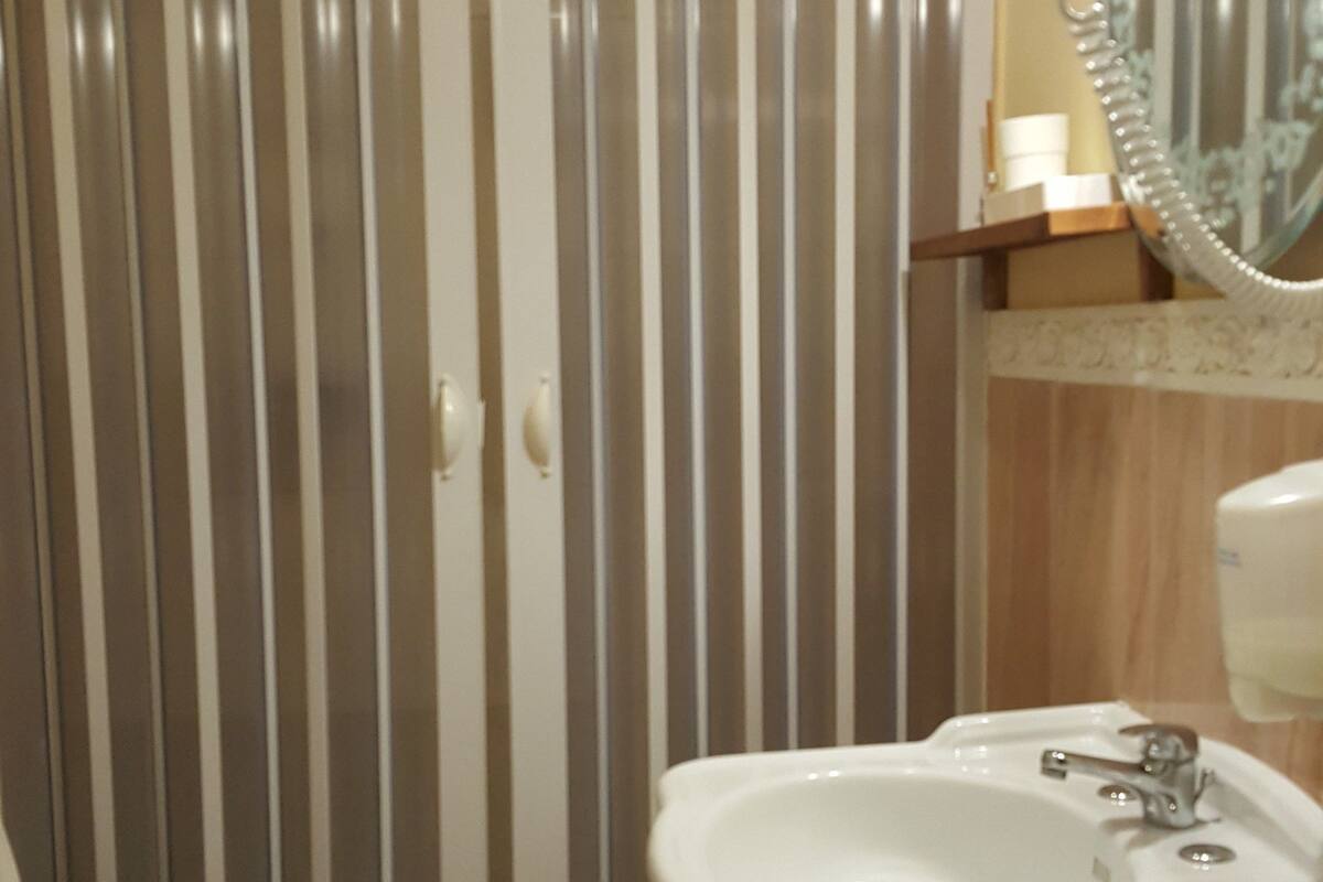 A bathroom with a toilet, sink, and shower.