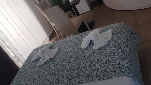 A modern hotel room with a bed, a desk, a chair, a plant, and a bathtub. - B&B Napoli Centro (Naples)