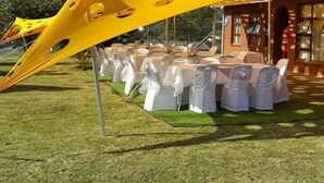 A tented outdoor event area with tables set for guests, surrounded by a building with brick walls. - Hlakula Lake Resort (Metz)