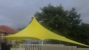 A yellow canopy structure over a gate, with a building and trees in the background. - Hlakula Lake Resort (Metz)