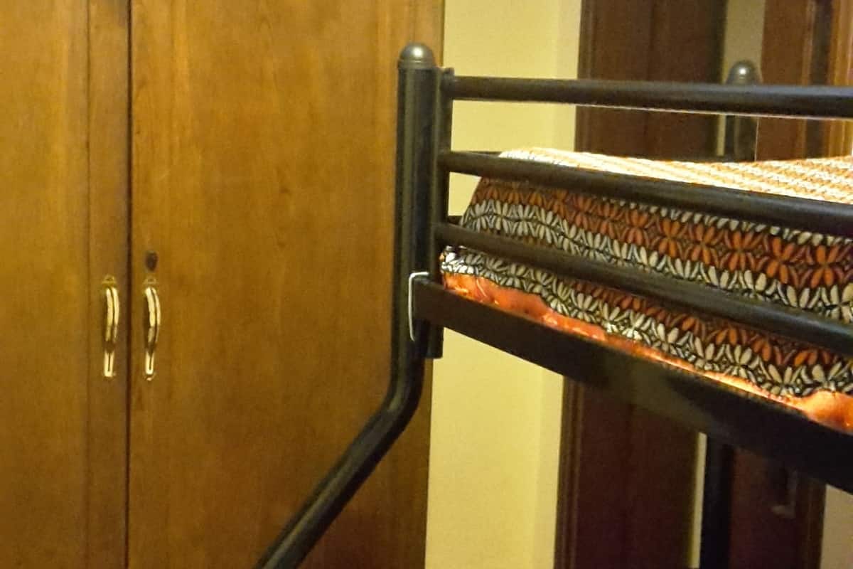 Une chambre avec un lit superposé, une armoire en bois et une porte.