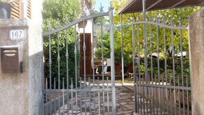 A gated entrance with a stone pathway leading to a wooden door. - Gessy's (Lucca)