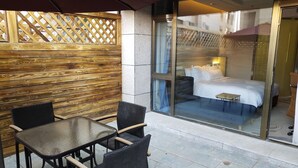 A hotel room with a large bed, a small table, and a glass door leading to the balcony. - Holiday Inn Express Anshan Downtown by IHG (Anshan)