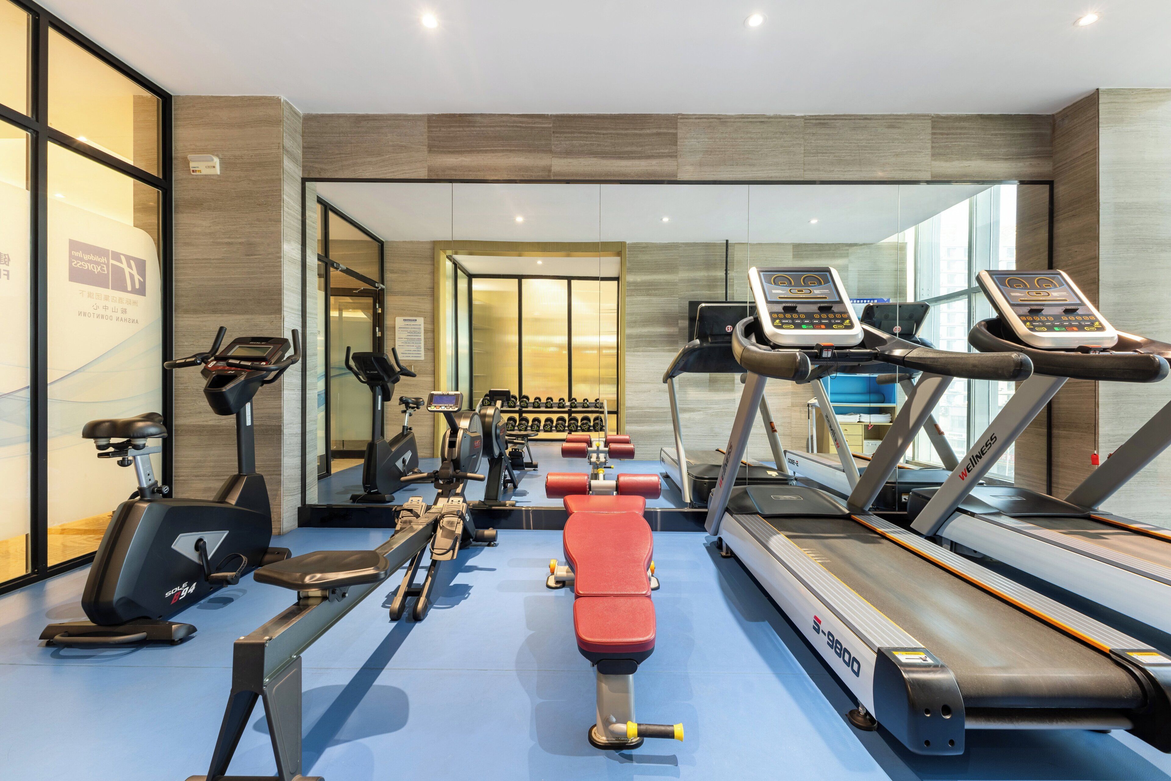Un gimnasio moderno con diverso equipo de ejercicio, incluyendo cintas de correr y bicicletas estáticas.