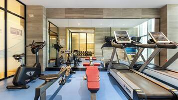 Un gimnasio moderno con diverso equipo de ejercicio, incluyendo cintas de correr y bicicletas estáticas.