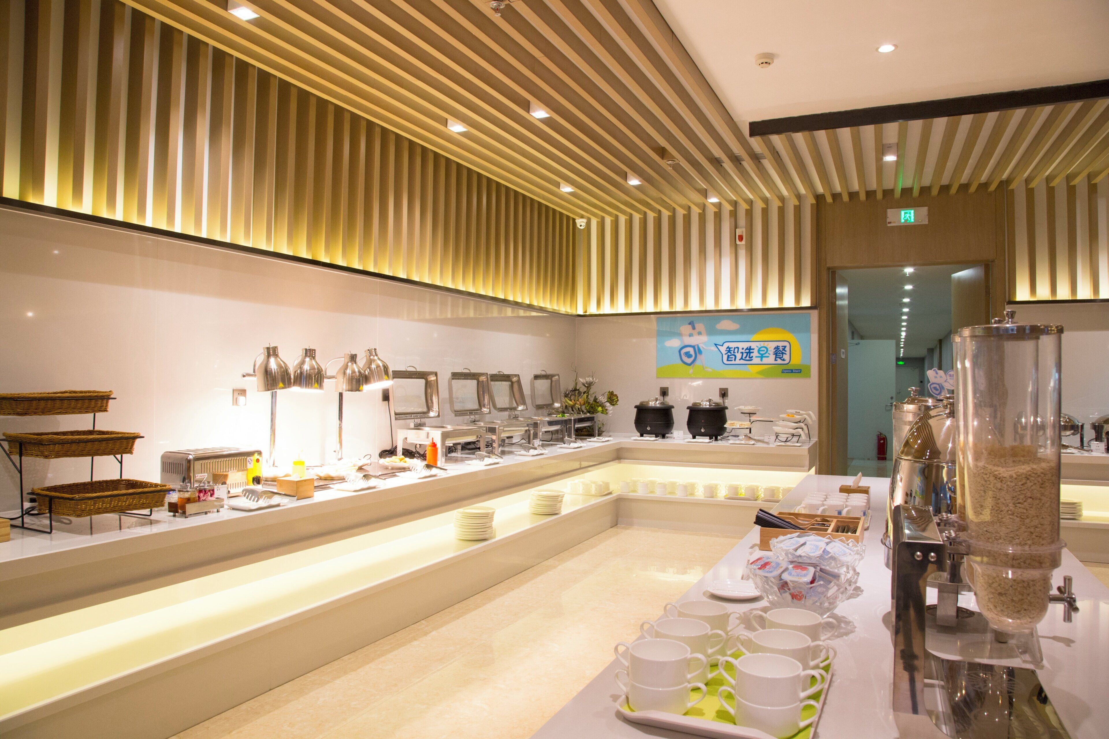 Montaje de bufé con múltiples estaciones de servicio, una variedad de platillos y un diseño interior moderno y limpio.