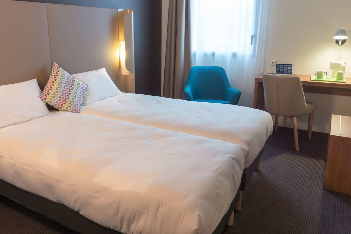 Une chambre d’hôtel avec un grand lit, un bureau, une chaise et une table de chevet.