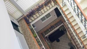 Un edificio residencial de varios niveles con escaleras, balcones y un pequeño jardín.