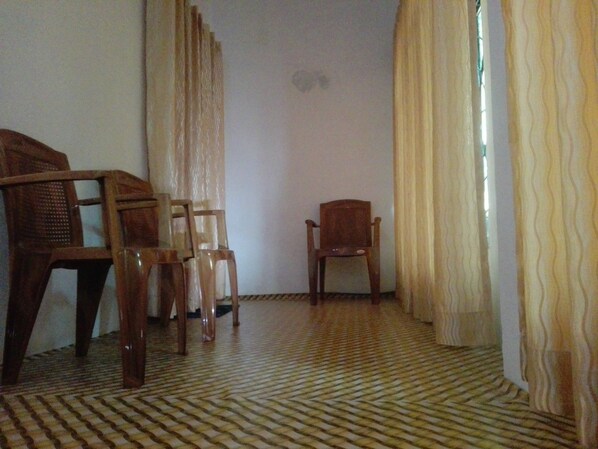 A room with a patterned floor, a wooden chair, and a sofa.