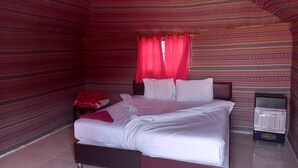 Quarto com cama, cortinas vermelhas, paredes estampadas e chão de azulejos.
