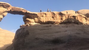 Um grupo de pessoas em formação rochosa com um arco natural.