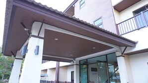 A building with a covered entrance, a visible staircase, and a sign indicating a business or office space. - Chanprasert House (Udon Thani)