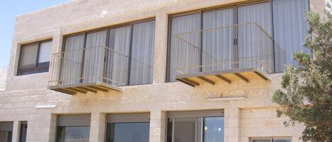 A modern two-story building with large windows and balconies.